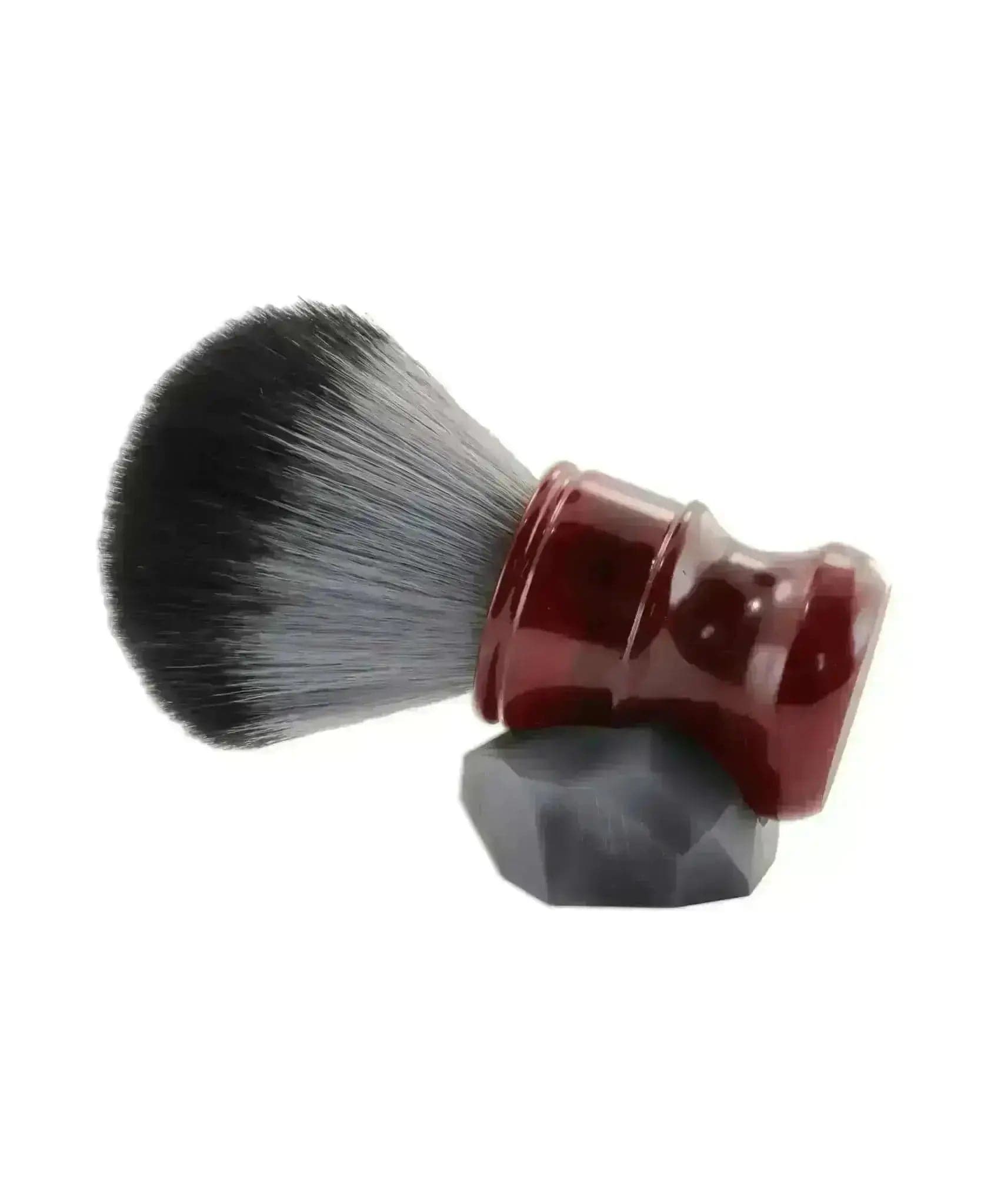 a red and black shaving brush on a white background